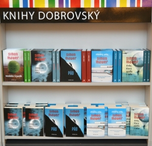 V přilehlém stánku byly Mawerovy knihy v prodeji jak v pevné, tak i v paperbackové vazbě.