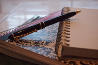 Leaning Pen on Notebooks